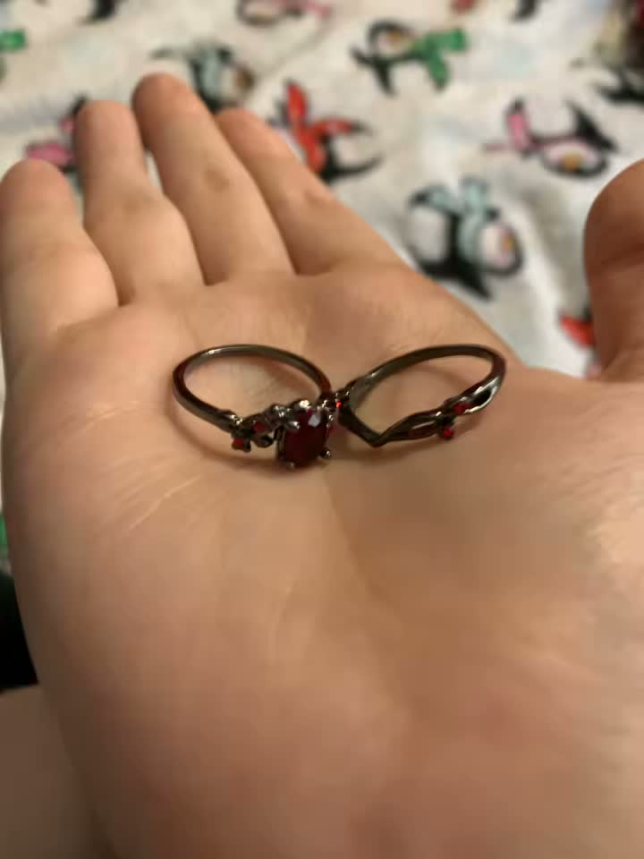 Blood Vine Ring and matching band held in a palm